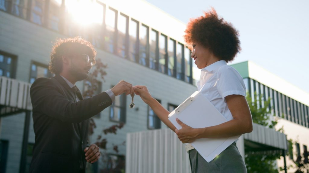 African woman trader real estate agent saleswoman realtor give bunch of keys to Arabian man Indian